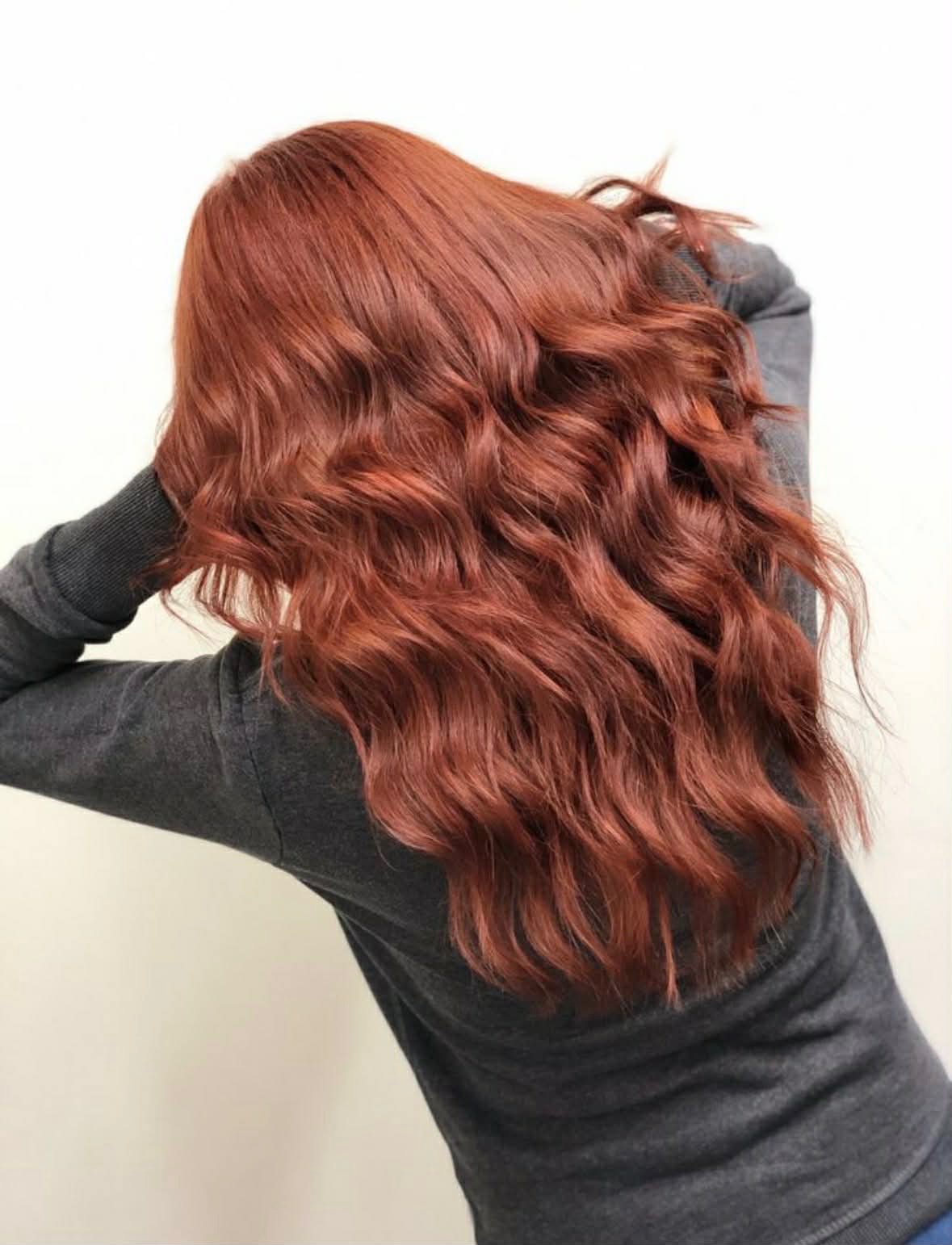 Vibrant copper red waves on long hair after a single-process color