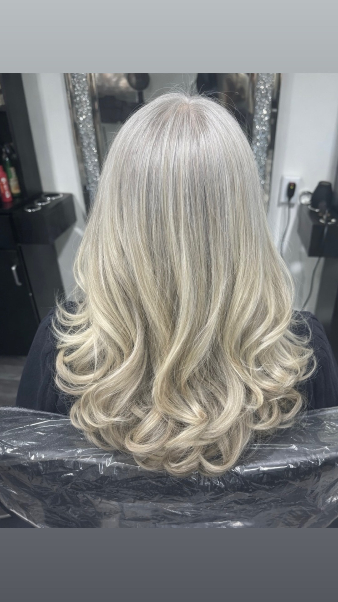 Icy platinum blonde curled hair after a full highlight and toner service